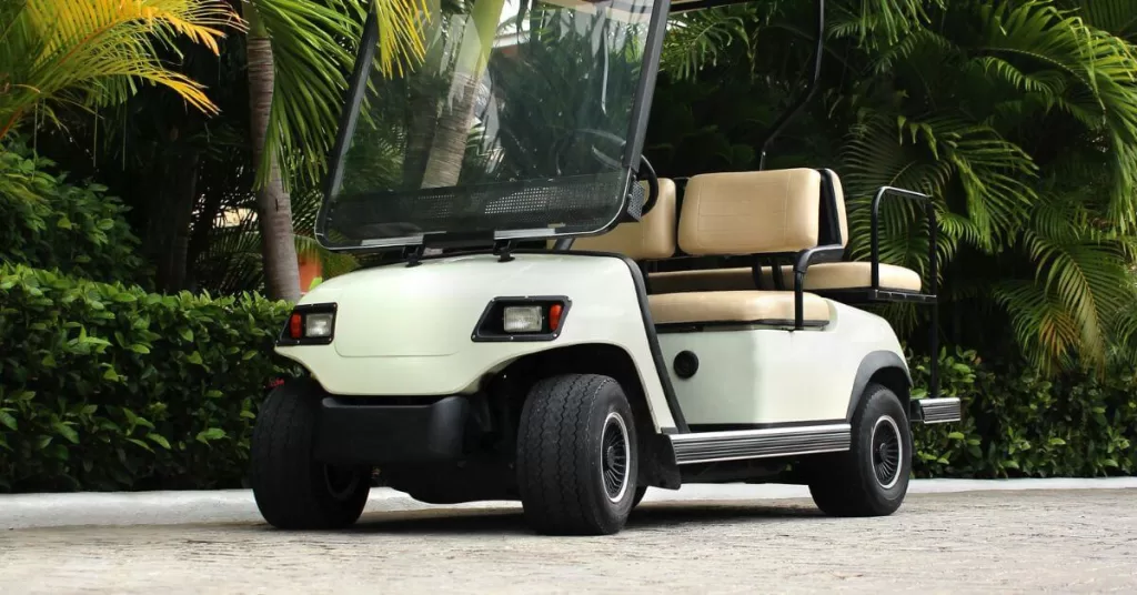 A photo of a golf cat surrounded by tall green palm trees